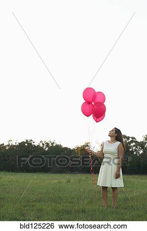 Mixed race woman with pink balloons in park View Large Photo Image Stock Photograph - Mixed race woman with pink balloons in park. Fotosearch