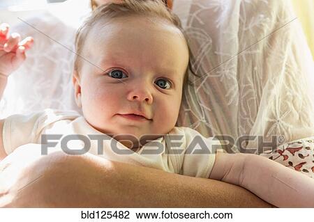 Stock Image - Mother holding smiling baby. Fotosearch