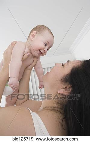 Stock Photo - Mother playing with Hispanic baby boy. Fotosearch