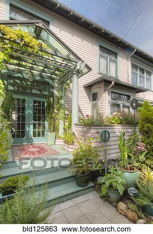 Stock Image - Plants on front steps of house. Fotosearch