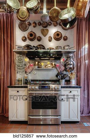 Stock Photo - Pots and pans hanging over oven. Fotosearch
