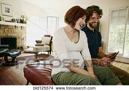Pregnant Caucasian couple using digital tablet View Large Photo Image Picture - Pregnant Caucasian couple using digital tablet. Fotosearch