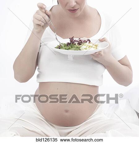 Stock Photography - Pregnant Caucasian woman eating salad. Fotosearch