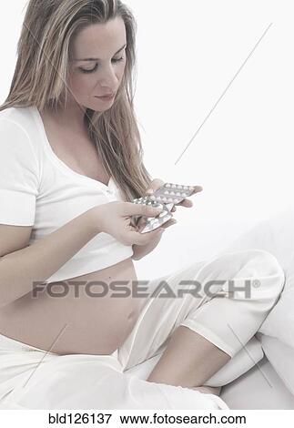Pregnant Caucasian woman taking vitamins View Large Photo Image Stock Photo - Pregnant Caucasian woman taking vitamins. Fotosearch