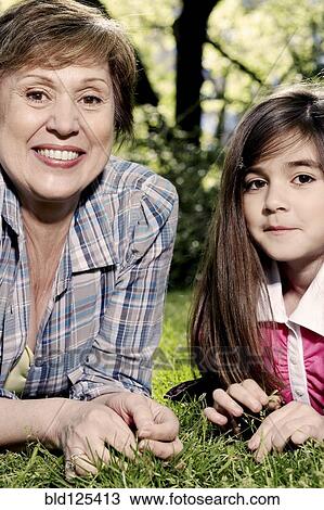 Senior Caucasian woman and granddaughter laying in grass View Large Photo Image Stock Image - Senior Caucasian woman and granddaughter laying in grass. Fotosearch