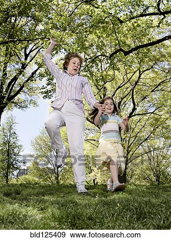 Senior Caucasian woman and granddaughter playing in park View Large Photo Image Stock Photo - Senior Caucasian woman and granddaughter playing in park. Fotosearch