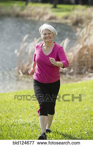 Senior Caucasian woman jogging in park View Large Photo Image Stock Photo - Senior Caucasian woman jogging in park. Fotosearch