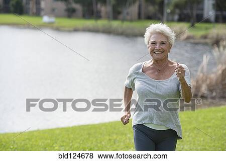 Stock Photo - Senior Caucasian woman jogging in park. Fotosearch