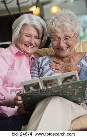 Picture - Senior Caucasian women looking at photo album. Fotosearch