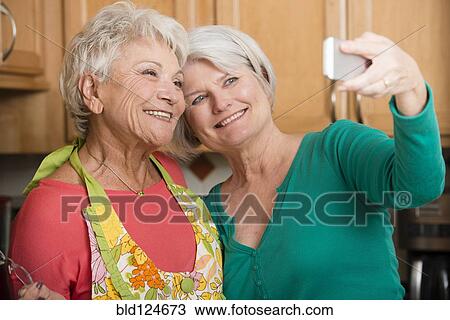 Senior Caucasian women taking self-portrait in kitchen View Large Photo Image Stock Image - Senior Caucasian women taking self-portrait in kitchen. Fotosearch