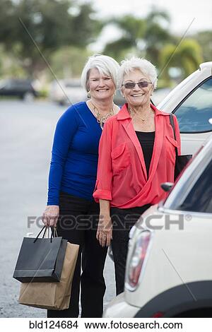 Senior Caucasian women with shopping bags in parking lot View Large Photo Image Picture - Senior Caucasian women with shopping bags in parking lot. Fotosearch