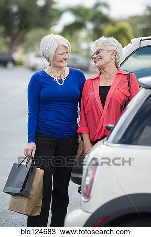 Senior Caucasian women with shopping bags in parking lot View Large Photo Image Stock Image - Senior Caucasian women with shopping bags in parking lot. Fotosearch