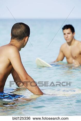 Surfers on surfboard in ocean View Large Photo Image Stock Photograph - Surfers on surfboard in ocean. Fotosearch