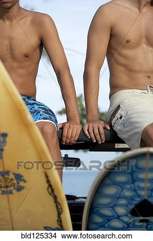 Picture - Surfers sitting in 4x4 with surfboards. Fotosearch