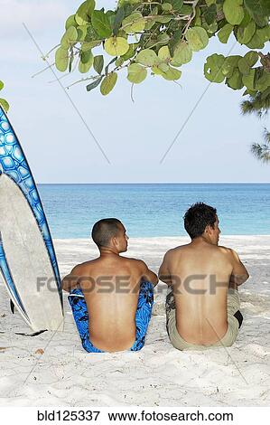 Surfers sitting together on beach View Large Photo Image Stock Photo - Surfers sitting together on beach. Fotosearch