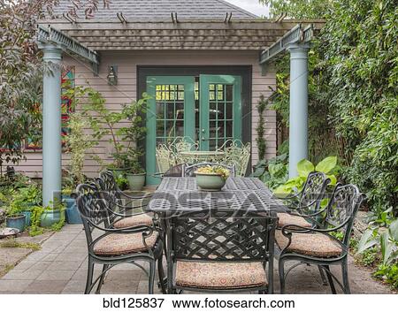 Stock Photo - Table and chairs in backyard garden. Fotosearch