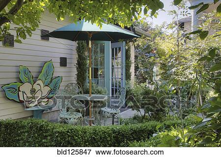 Table and chairs with umbrella on patio View Large Photo Image Stock Photo - Table and chairs with umbrella on patio. Fotosearch