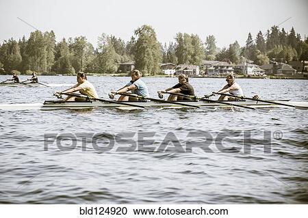 Stock Image - Teenagers rowing scull on lake. Fotosearch