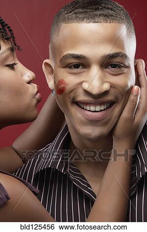 Woman leaving lipstick kiss on boyfriend's cheek View Large Photo Image Stock Photograph - Woman leaving lipstick kiss on boyfriend's cheek. Fotosearch