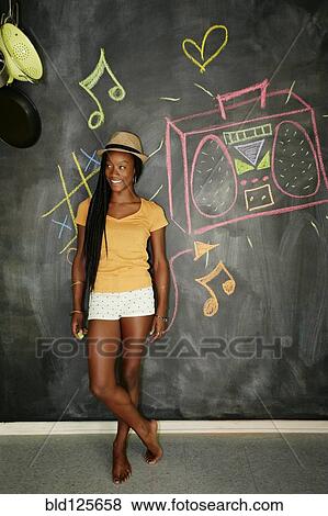 Woman smiling by blackboard wall View Large Photo Image Stock Photo - Woman smiling by blackboard wall. Fotosearch