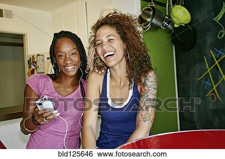 Women listening to headphones together View Large Photo Image Stock Photograph - Women listening to headphones together. Fotosearch