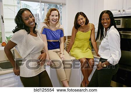 Women relaxing together in kitchen View Large Photo Image Picture - Women relaxing together in kitchen. Fotosearch