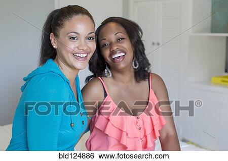 Women smiling together in bedroom View Large Photo Image Stock Photograph - Women smiling together in bedroom. Fotosearch