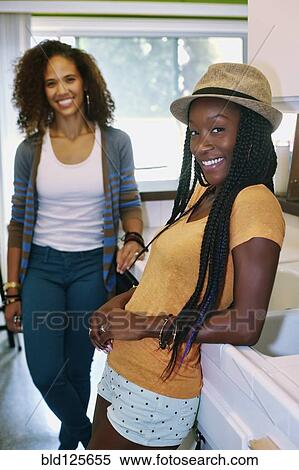 Stock Photography - Women smiling together in kitchen. Fotosearch