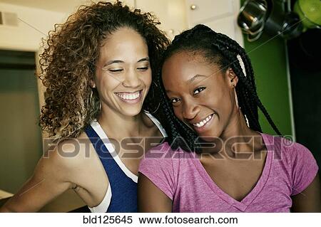 Stock Photography - Women smiling together indoors. Fotosearch