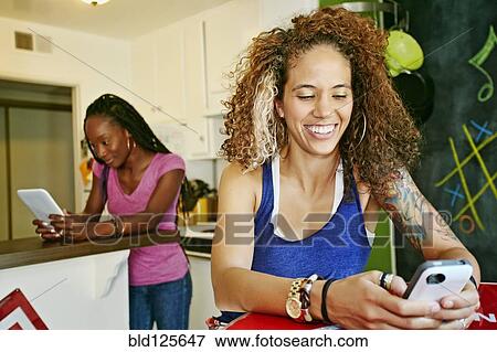 Women using technology in kitchen View Large Photo Image Stock Photo - Women using technology in kitchen. Fotosearch