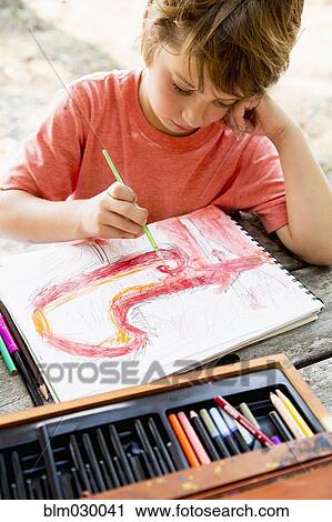 Stock Image - Caucasian boy painting with watercolors. Fotosearch