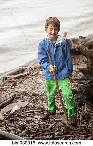 Caucasian boy playing with sticks by river View Large Photo Image Stock Photograph - Caucasian boy playing with sticks by river. Fotosearch