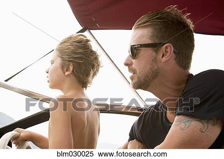 Stock Photography - Caucasian father and son driving speedboat. Fotosearch