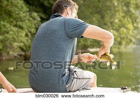 Caucasian man catching fish in still lake View Large Photo Image Stock Photograph - Caucasian man catching fish in still lake. Fotosearch