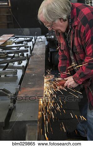 Caucasian man sanding metal in metal shop View Large Photo Image Stock Photography - Caucasian man sanding metal in metal shop. Fotosearch