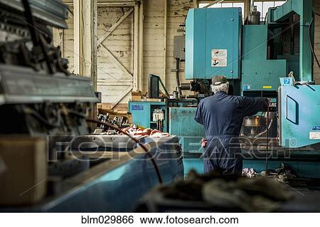 Caucasian man using machinery in metal shop View Large Photo Image Stock Photograph - Caucasian man using machinery in metal shop. Fotosearch