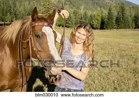 Caucasian woman walking horse in rural landscape View Large Photo Image Stock Image - Caucasian woman walking horse in rural landscape. Fotosearch