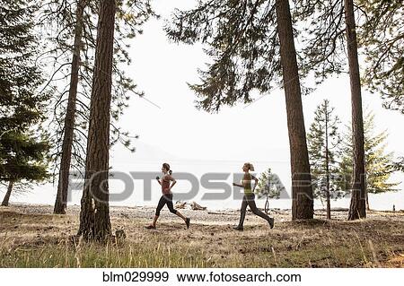 Caucasian women running in forest View Large Photo Image Stock Photo - Caucasian women running in forest. Fotosearch