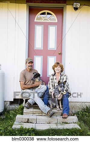 Couple sitting with dogs on front steps View Large Photo Image Stock Photo - Couple sitting with dogs on front steps. Fotosearch