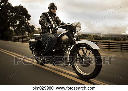 Man riding motorcycle on rural road View Large Photo Image Stock Image - Man riding motorcycle on rural road. Fotosearch
