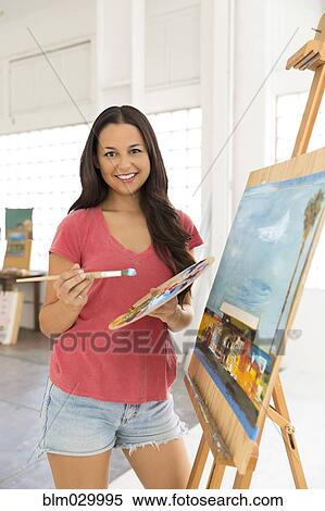 Portrait of smiling woman painting at easel View Large Photo Image Stock Photography - Portrait of smiling woman painting at easel. Fotosearch