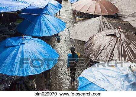 Stock Image - Rain falling over tarps and awnings of market stalls, Ubud, Bali, Indonesia. Fotosearch
