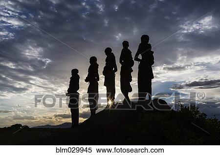 Stock Photography - Silhouettes of pregnant woman under cloudy sky at sunset, Nyangaton, Ethiopia. Fotosearch