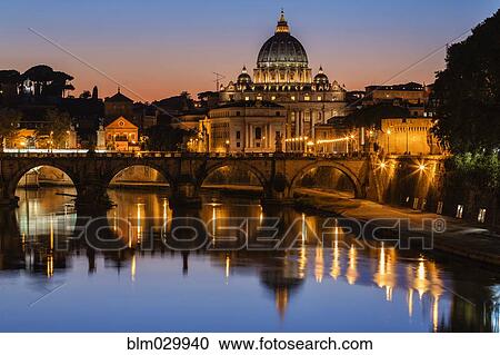 Stock Image - St. Peter's Basilica and Tiber River illuminated at dusk, Rome, Lazio, Italy. Fotosearch