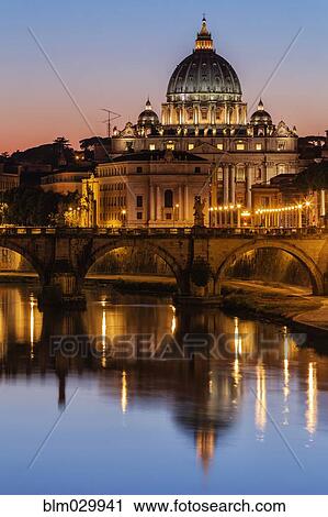 Stock Image - St. Peter's Basilica and Tiber River illuminated at dusk, Rome, Lazio, Italy. Fotosearch