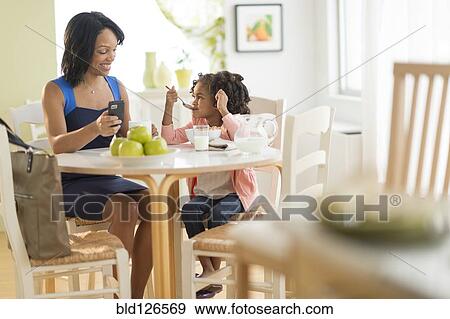 African American mother and daughter at breakfast table View Large Photo Image Stock Photo - African American mother and daughter at breakfast table. Fotosearch