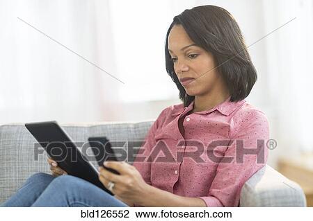 African American woman using cell phone and digital tablet View Large Photo Image Stock Image - African American woman using cell phone and digital tablet. Fotosearch