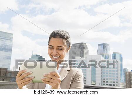 Asian businesswoman using digital tablet on urban balcony View Large Photo Image Stock Photo - Asian businesswoman using digital tablet on urban balcony. Fotosearch