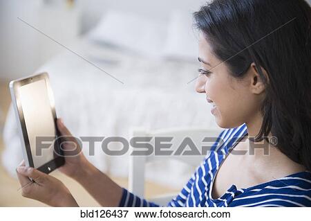 Stock Photo - Asian woman using digital tablet. Fotosearch