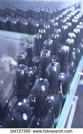 Stock Image - Bottles on Conveyor Belt in Factory. Fotosearch